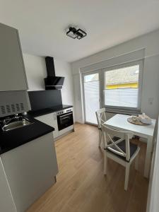 a kitchen with a table and a sink and a stove at RheinSchatz Apartments 6 in Oberwesel +3 photos