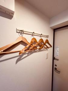 Un armario con un montón de perchas de madera en una habitación. en Raffine103, en Sapporo