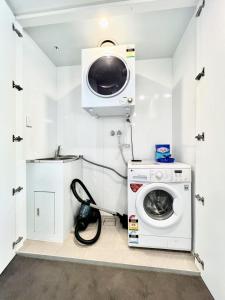 a laundry room with a washing machine and a microwave at Modern Comfort Hurstville 1BR Wifi Train Business in Sydney