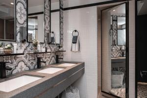un bagno con due lavandini e un grande specchio di Atlas Hostel & Backpackers a Hong Kong