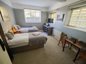 une chambre avec deux lits, une table et une chaise dans l'établissement Bossington Bunkhouse, à Minehead