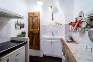 a kitchen with a sink and a wooden door at Le petit carnot in Apt