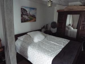 ein Schlafzimmer mit einem Bett und einem Spiegel in der Unterkunft maison gite 6 pièces tourisme in Loyat
