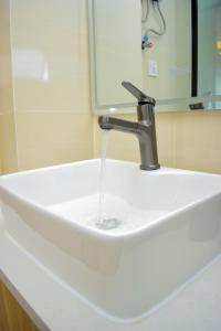 een gootsteen met water uit een kraan bij Luxe Homes by cassie in Nairobi +12 foto's