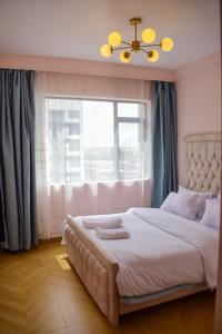 een slaapkamer met een groot bed en een raam bij Luxe Homes by cassie in Nairobi