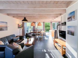 a living room with a couch and a table at Ferienhaus Wiesengeflüster E5 - gruppenfreundlich in Randlage mit Fasssauna in Röbel