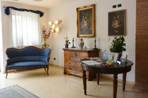 ein Wohnzimmer mit einem blauen Stuhl und einem Tisch in der Unterkunft Hotel Ristorante Italia in Certosa di Pavia