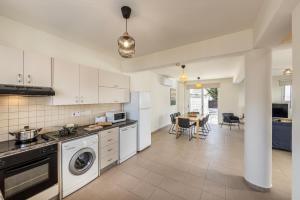 a kitchen with a washer and dryer and a table at Protaras Villa Cemelia in Protaras