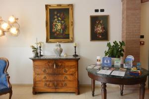 a room with a wooden dresser and a painting on the wall at Hotel Ristorante Italia in Certosa di Pavia