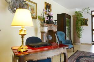 Zimmer mit einem Tisch, einer Lampe und Stühlen in der Unterkunft Hotel Ristorante Italia in Certosa di Pavia
