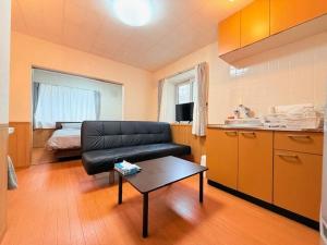 a living room with a couch and a table and a bed at Choyo101 in Sapporo