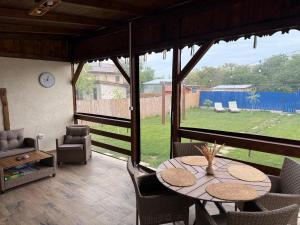 a patio with a table and chairs and a view of a yard at Casa lui Matei Murighiol in Murighiol
