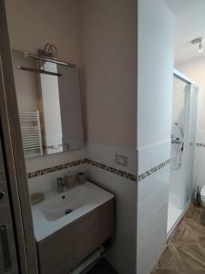 a bathroom with a sink and a mirror and a shower at Il vecchio portone, Zubiena, BI in Borriana