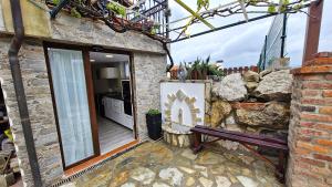 a stone building with a bench next to a window at Serendipia 52 in Suances
