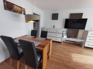 Un comedor con mesa y sillas y un televisor. en BodenSEE Apartment Wasserburg Sonnhaldenstraße, en Wasserburg