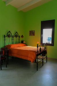a green bedroom with a large bed with orange sheets at Rdm affittacamere in Albiano