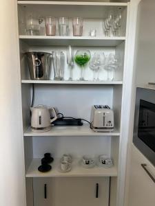ストラスブールにあるSoftwave Wellness Home strasbourg with garage includedのグラスなどの台所用品が入った戸棚