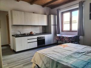 a kitchen with a bed and a sink in a room at The square in Orosei