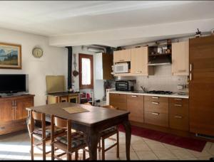 a kitchen with a wooden table and a dining room at Casa montagna relax in Cedegolo