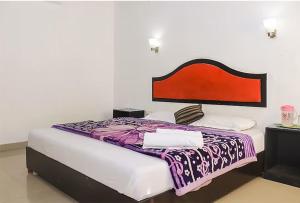 a bedroom with a bed with a purple and white blanket at GlenBrook HomeStay in Munnar