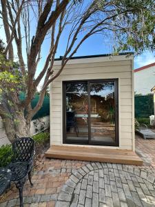 Un pequeño cobertizo con una ventana y un banco. en Peony Place, en Ciudad del Cabo