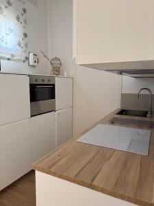 a white kitchen with a sink and a stove at Bianca's home in Cavallino-Treporti