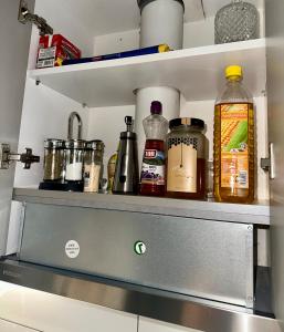 a shelf with many bottles on it in a kitchen at 4SeasonsApartment in Karditsa +16 photos