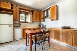 una cucina con mobili in legno e un tavolo in legno di Villa Hra Lefkada a Nikiana