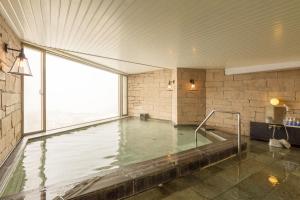 a swimming pool in a room with a large window at Midagahara Hotel in Tateyama +45 photos