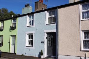 eine Reihe bunter Häuser auf einer Straße in der Unterkunft Stylish, central Beaumaris cottage in Beaumaris