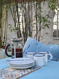 einen Tisch mit Tellern und Tassen darüber in der Unterkunft Stylish, central Beaumaris cottage in Beaumaris + 7 Fotos