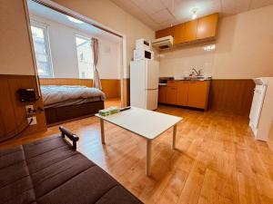 札幌Choyo 102的一间有桌子、厨房和床的房间