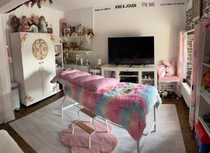 een woonkamer met een grote roze en blauwe deken bij Suite Retour en Enfance in Dol-de-Bretagne