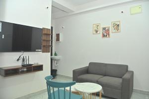 een woonkamer met een bank en een tafel bij AVO Nest Kondapur - 1 BHK Fully Furnished Penthouse #601 in Kondapur