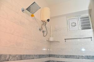 een douche in een badkamer met een douchekop bij AVO Nest Kondapur - 1 BHK Fully Furnished Penthouse #601 in Kondapur +15 foto's