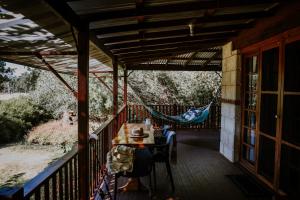 eine Veranda eines Hauses mit einer Hängematte darauf in der Unterkunft Clover Cottage Country Retreat in Manjimup