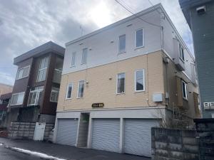 a building with two garage doors on a street at Choyo 105 in Sapporo