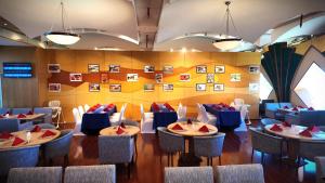 a dining room with blue tables and chairs at Oryx Grand Hotel Jebel Hafeet in Al Ain