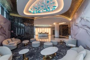 eine Lobby mit Sofas und Tischen in einem Gebäude in der Unterkunft Elania Resort & Spa in Cluj-Napoca