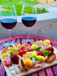 two glasses of red wine and a plate of food at Luisela Mar Algarve in Carvoeiro