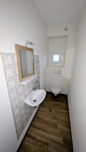 a white bathroom with a sink and a toilet at Le gîte "Guiste" in Cléder