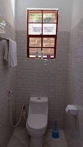 a bathroom with a white toilet and a window at Makinihomestay in Arusha