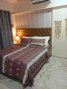 a bedroom with a bed with a brown comforter at Lakefront Lounge-Luxe 1bhk condo with 2queen beds-2baths in Mumbai