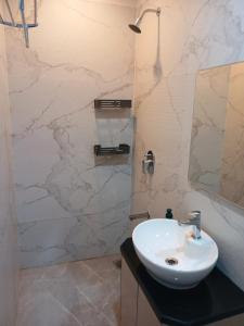 a bathroom with a white sink and a mirror at Lakefront Lounge-Luxe 1bhk condo with 2queen beds-2baths in Mumbai +69 photos