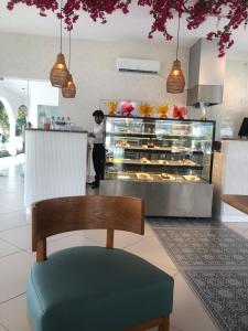 a person standing in front of a bakery with pastries at Santorini 2BR Resort Apt - Negombo Beach & Airport in Negombo