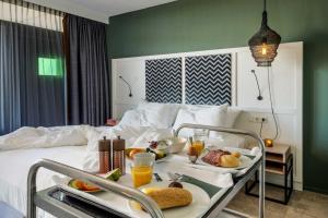 a hotel room with a tray of food on a bed at Paal 8 Hotel aan Zee in West aan Zee