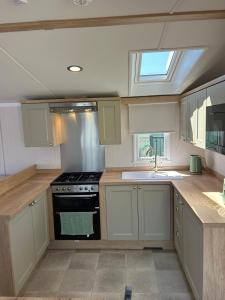 a kitchen with white cabinets and a stove top oven at Provence Holiday home by the river Nidd 8 in Knaresborough