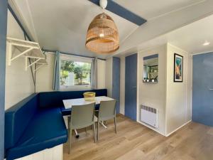 a dining room with a blue couch and a table at Camping Les Cigales in Mandelieu-La Napoule