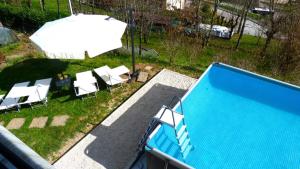 an overhead view of a swimming pool with chairs and an umbrella at Casa Modigliani - Tra Arte e Natura in San Quirico