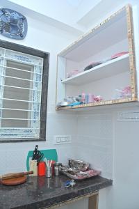 a kitchen with a counter top and a shelf at 1 BHK Penthouse Fully Furnished with Lift Access #602 in Kondapur